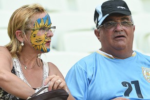 Una uruguaya pintada a tope con los colores patrios acompañada de un compatriota con la celeste.