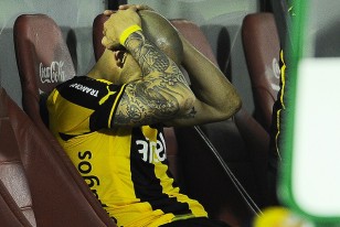 Damián Macaluso se toma la cabeza en el banco de suplentes. Sufrió distensión muscular en recto.