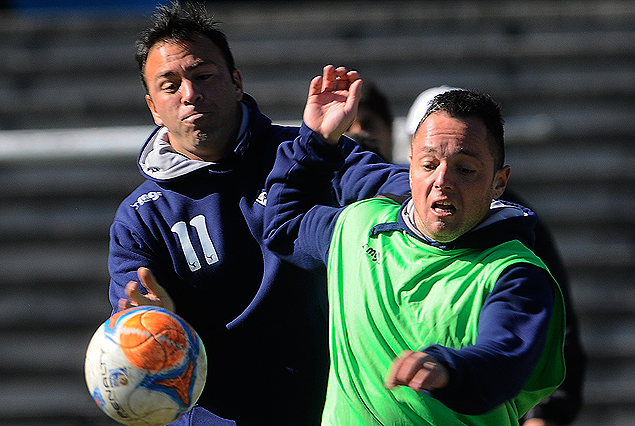 Horacio Peralta y Rodrigo De Olivera van con todo a una pelota dividida en el entrenamiento albiceleste en el Estadio Charrúa. 