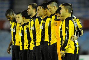 Los jugadores de Peñarol y el respetuso silencio en el postrero homenaje a Julio César Abbadie y Dante Cocito. 