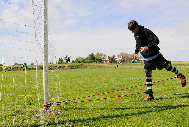 Gastón Bueno en plena sesión de estiramiento en el Complejo Walter Devoto; el zaguero no entró a la cancha y es difícil que juegue el sábado. 