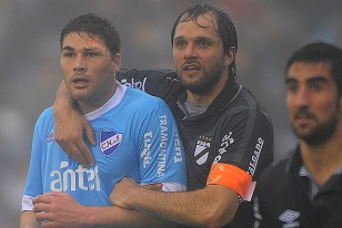 Rafael García con el apósito sobre la ceja izquierda es tomado por Jadson Viera.