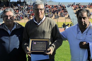 Alvaro Gutiérrez con la plaqueta que le entregaron los dirigentes de Atenas.