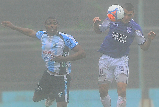 El violeta Mauro Arrambarri se lleva la pelota ante la marca de Hugo Silveira. 