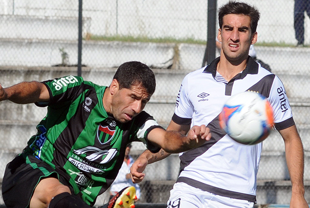 Andrés Aparicio rechaza la pelota ante la mirada de Matías Castro