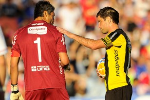 Antonio Pacheco, pelota en mano, conversa con Gustavo Munúa, momentos antes de ejecutar tiro el penal que dejó sin invicto al arquero tricolor.