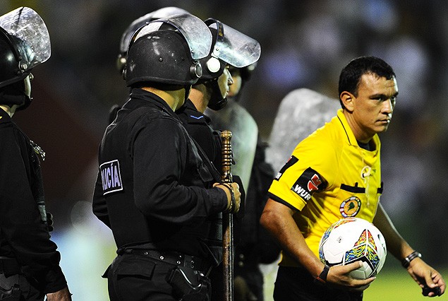 El juez Alejandro Mancilla se marcha de la cancha custodiado por efectivos policiales.  Bochornoso final.