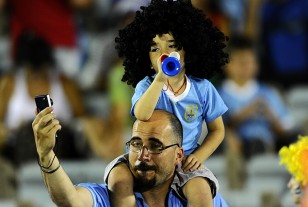 El niño en andas de su padre, con peluca imitando el peinado de Mauricio Lemos.