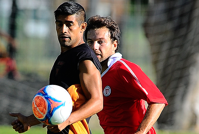 Emanuel Centurión en el control de la pelota y la marca de Claudio Herrera. 