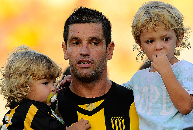 Antonio Pacheco posa con dos de sus tres hijos. Catalina con la camiseta de Peñarol y Benjamín.