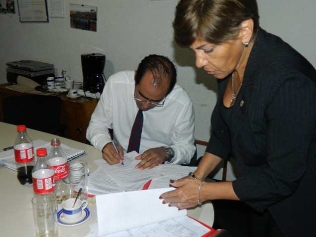 El presidente de la Comisión Disciplinaria, Dr. Fernando Sosa, firmando la medida cautelar contra Rampla Juniors tras la redaón realizada por la secretaria administrativa del órgano, Sra. Ana de los Santos.