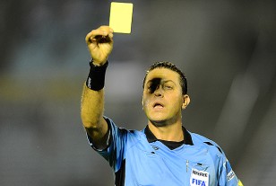 Fernando Falce, tarjeta amarilla en alto. Mostró en total once tarjetas, diez amarillas y una roja.