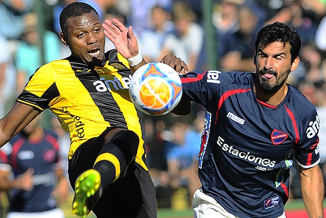Marcelo Zalayeta y Michel Acosta en el intento de controlar la pelota. 