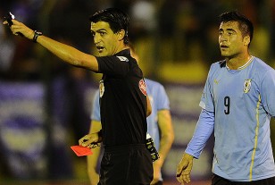 Leodan González con la tarjeta roja en mano. Expulsó a Cristian González, Jaime Báez y el hondureño Moncada.