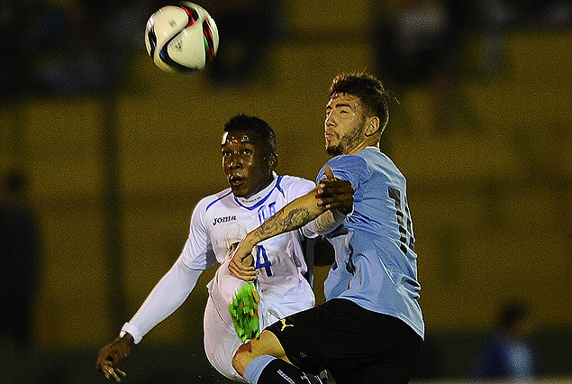 El hondureño Jhom Suazo y Enrique Etcheverry se disputan la posesión del balón.