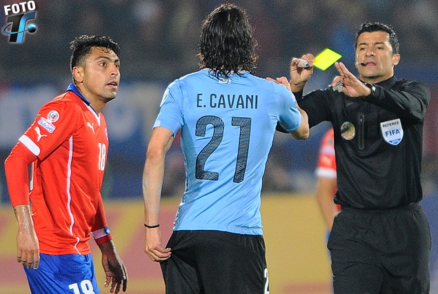 Gonzalo Jara, Edinson Cavani con la mano en la zona agredida por el chileno y el juez Sandro Ricci con la tarjeta amarilla en la mano.