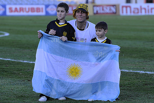 Pablo Migliore celebrando con sus dos pequeños hijos y la bandera de Argentina.