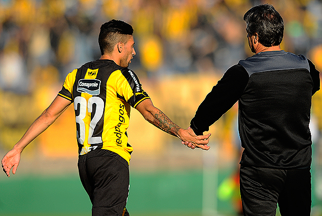 Jonathan Urretaviscaya y Pablo Bengeochea, chocan sus manos en el festejo del primer gol aurinegro.