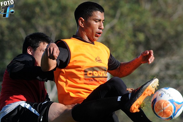 Horacio Sequeira (Fénix) maniobra con la pelota ante la marca del zaguero Guillermo De Los Santos (Defensor Sporting). 