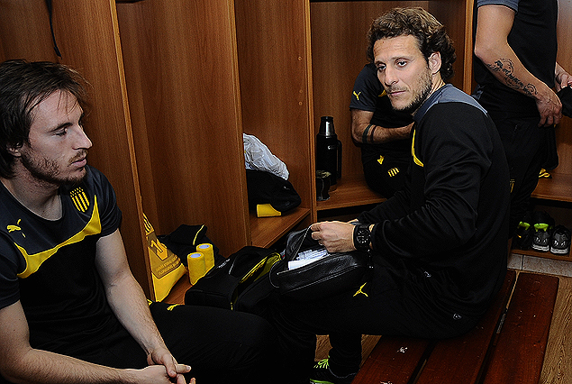 Hernán Novick escolta a Diego Forlán en el vestuario.