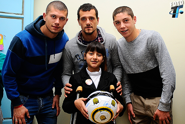 El arquero Gastón Guruceaga, Matías Aguirregaray y Federico Valverde en el Pereira Rossell con la sonrisa de la nena y la pelota de los aurinegros. 