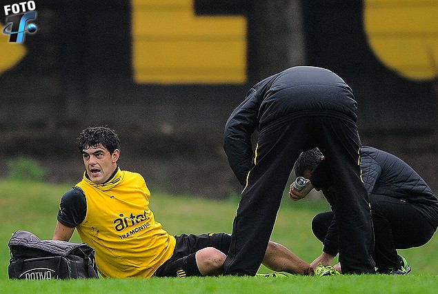 Luis Aguiar, tendido en el suelo es asistido por el Dr. Deccia, por el golpe que recibió en el pie izquierdo.