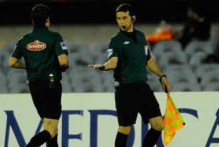 El línea Daniel Castro en su mano muestra la piedra que fue lanzada a la cancha.