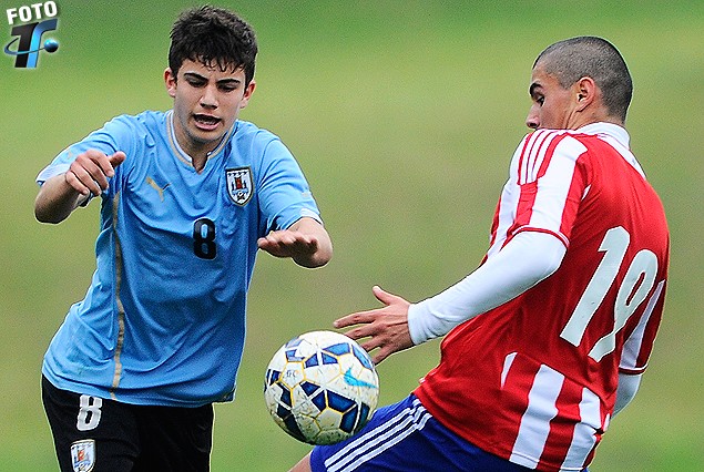 Mateo Sena disputa el balón con el defensor guaraní. Uruguay y Paraguay empataron 2:2.