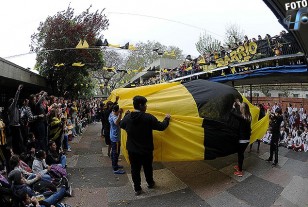 Los hinchas y la bandera en la visita a la Escuela del barrio Peñarol. 
