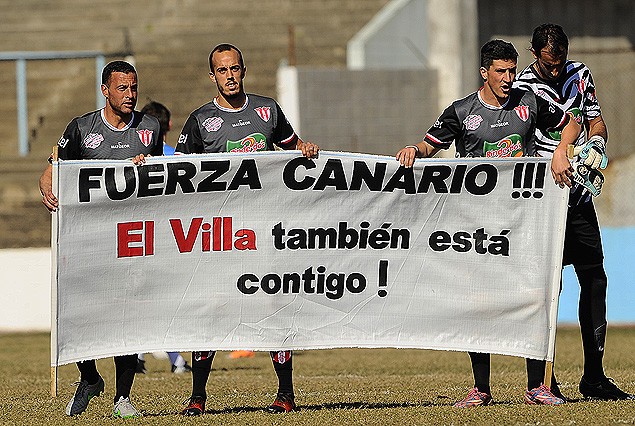 Los futbolistas del Villa con la pancarta para Angel Suárez